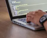 Dłoń pisze kod CSS, optymalizując pliki do wersji min.